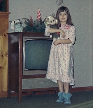 Young child standing next to 1965 Television