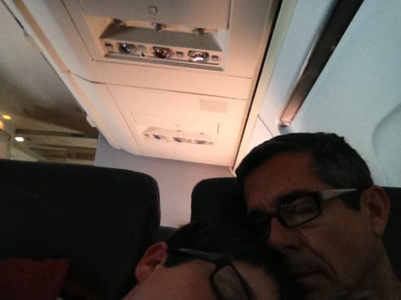 Father and Son nestled close and sleeping on airplane
