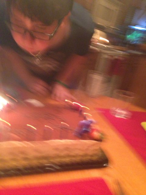 Blurry photo of 13 year old blowing out birthday candles