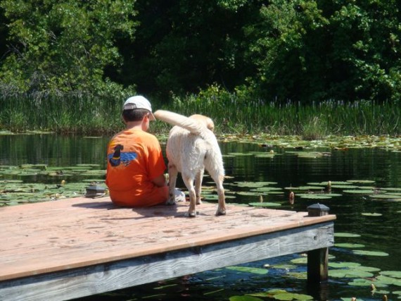Boy and dog on lake dock