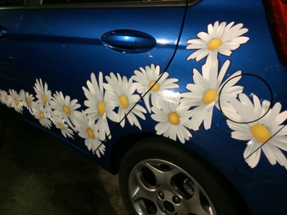 small blue car with daisies painted on side