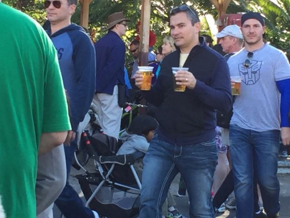 Man carrying a large beer in each hand at Disney