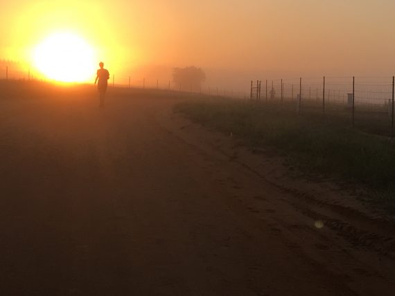 Teen running red dirt road