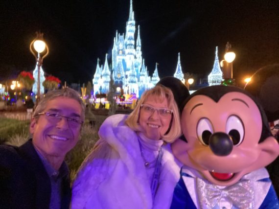 Two adults and Mickey Mouse at Magic Kingdom