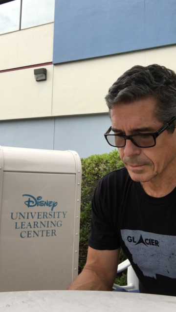 Man sitting next to Disney University trash can