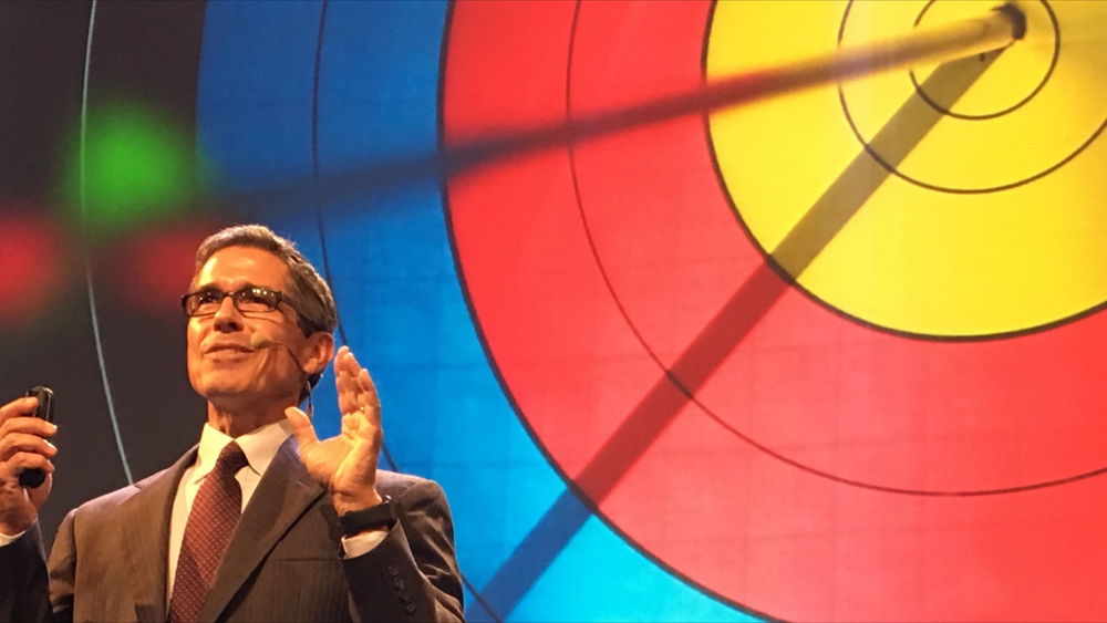 Disney speaker Jeff Noel on stage in front of a giant bullseye