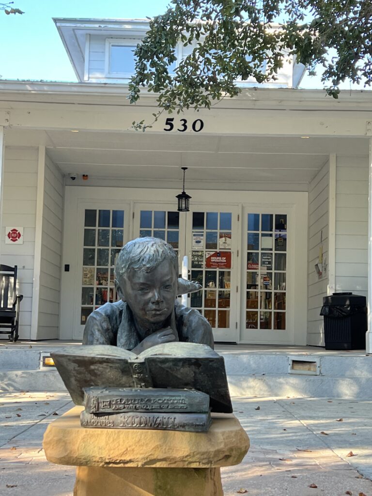 statue of boy reading a book