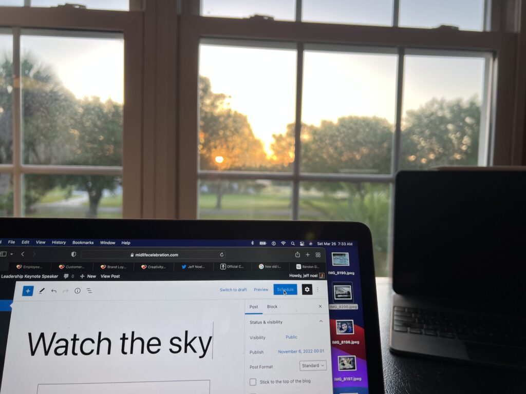 laptop by desk window at sunrise