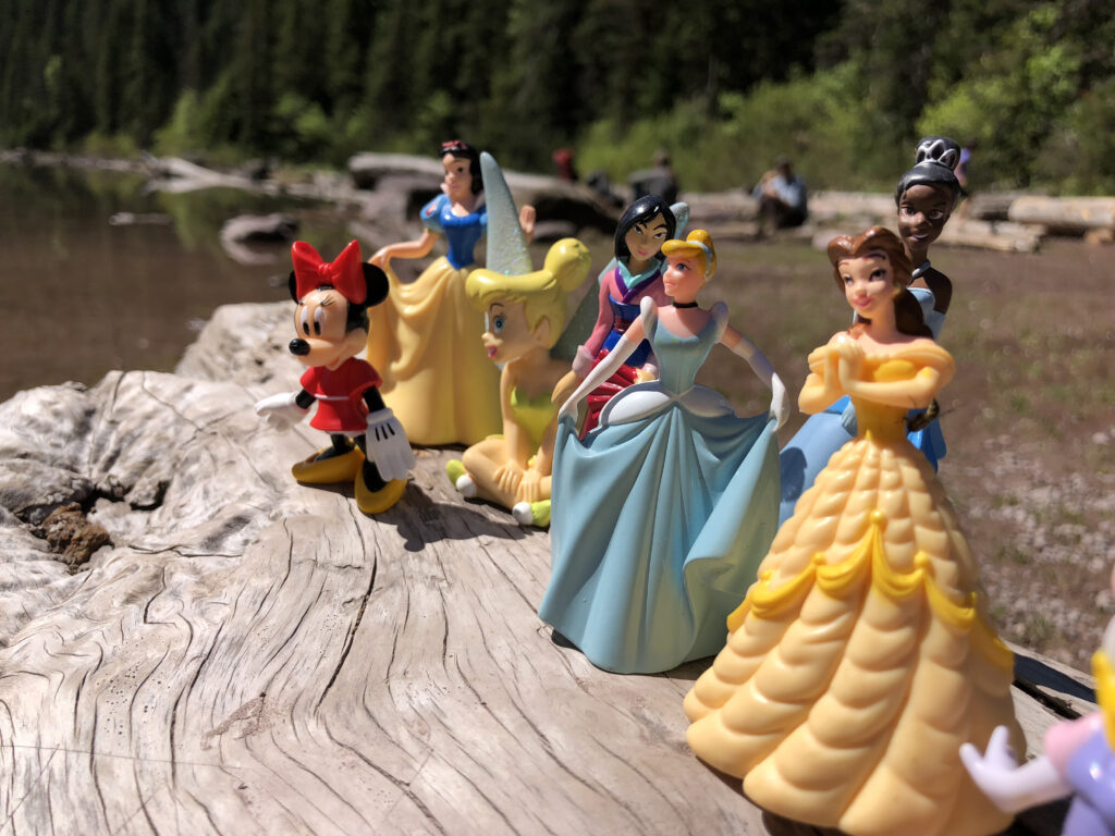 Disney plastic character toys at a mountain lake