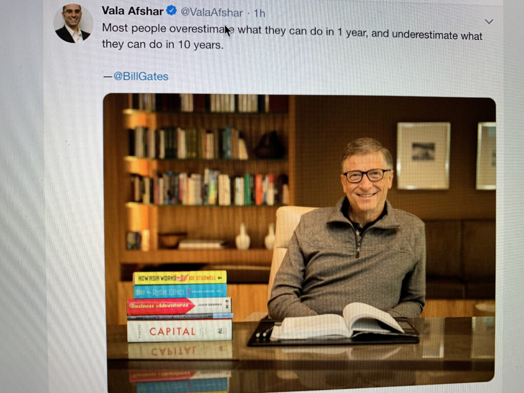 bill gates at a desk with books
