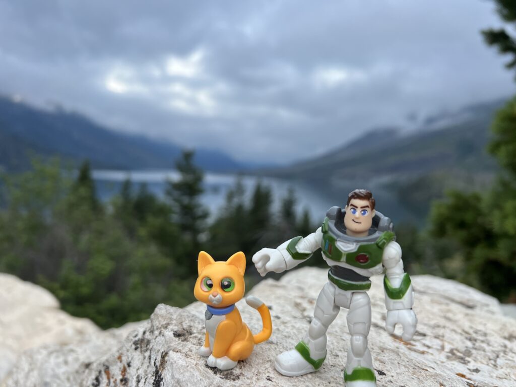 Two small Disney figurines in the mountains