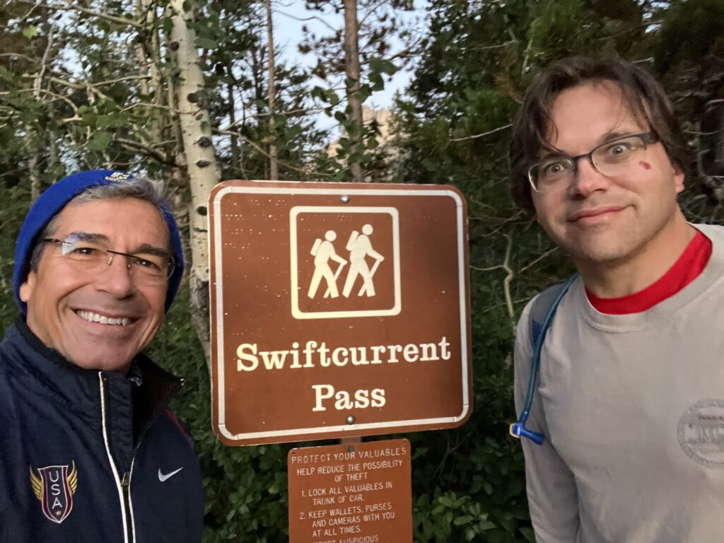 Two men next to trail head sign