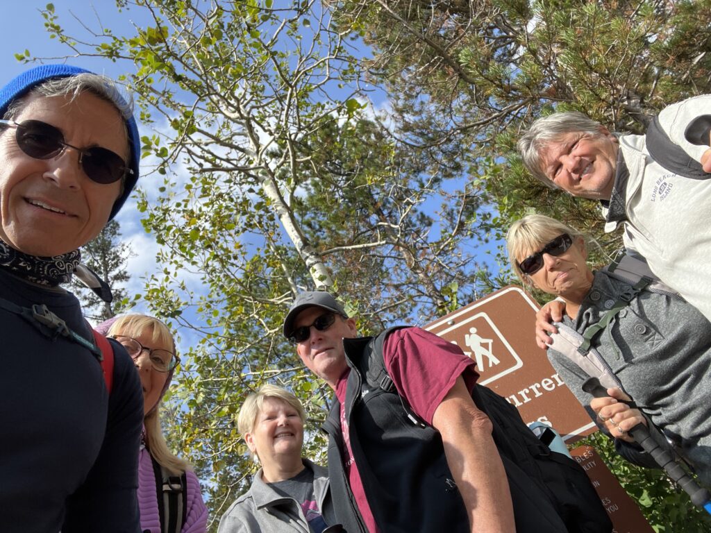Group of hikers by a trail head sign
