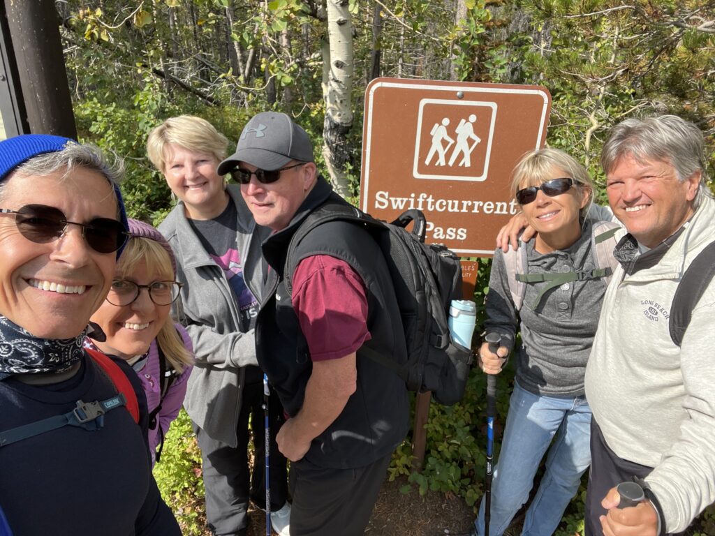 Group of hikers by trail head sign