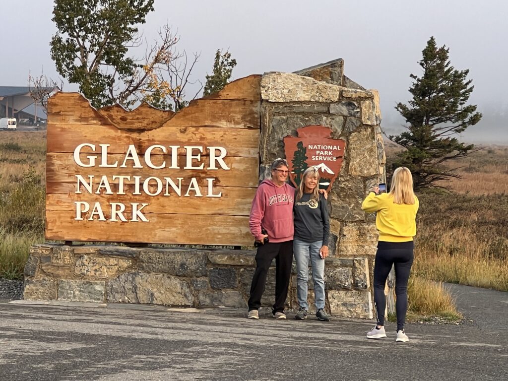 Three people at national park sign