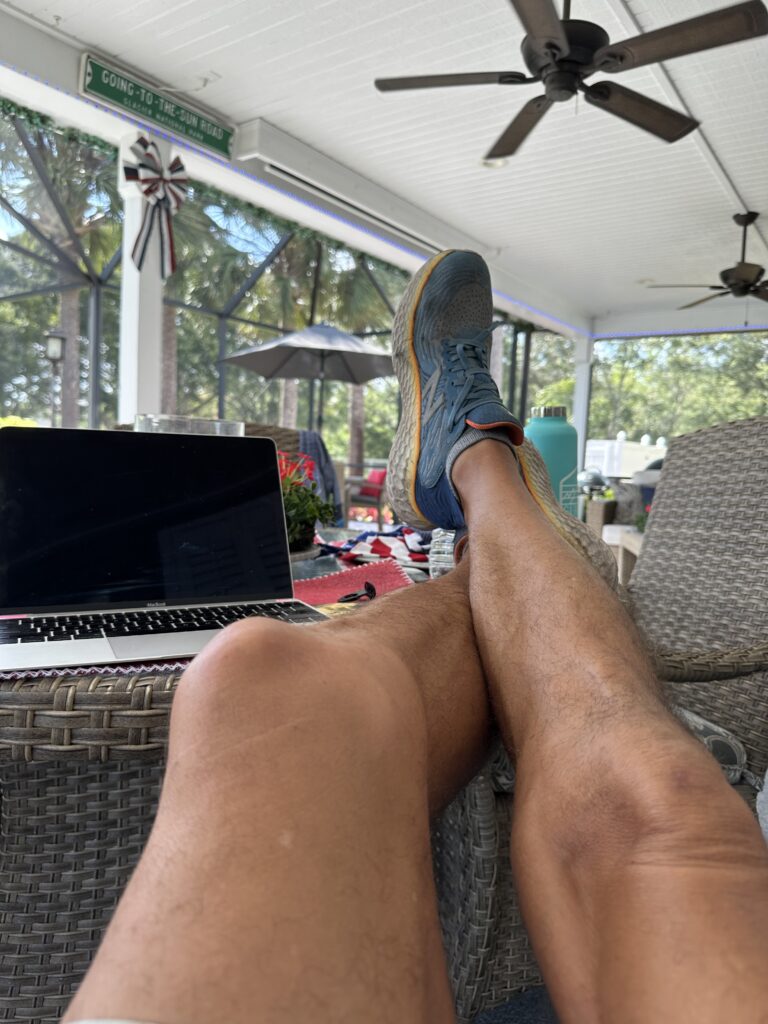 man's feet propped on patio table
