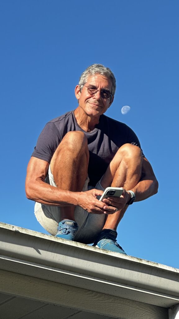 Man squatting on a house roof