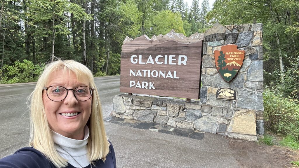 Woman by national park sign