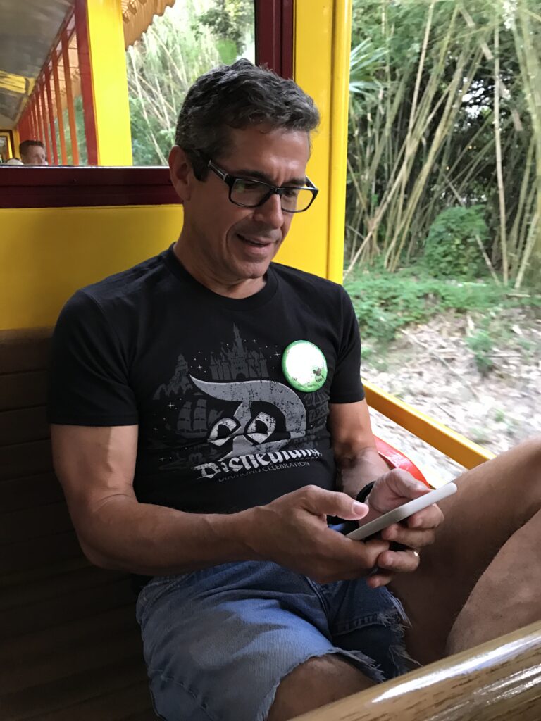Disney keynote speaker writing a book on his phone on a Disney train
