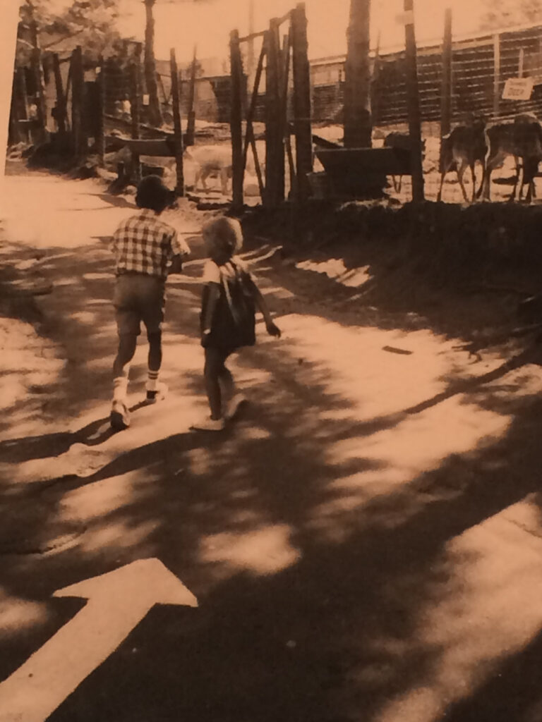 Black-and-white photo of two kids at an animal park