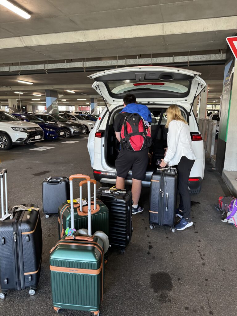 Two people loading luggage into a van