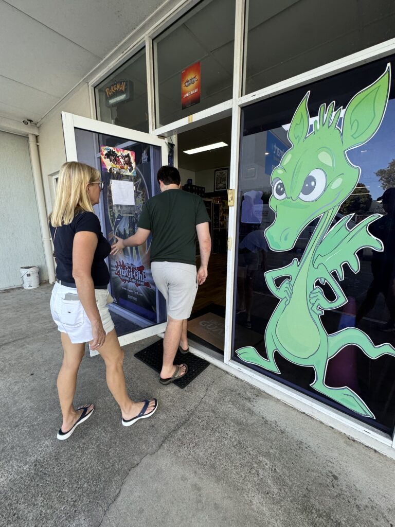 Two people entering building with green dragon wall