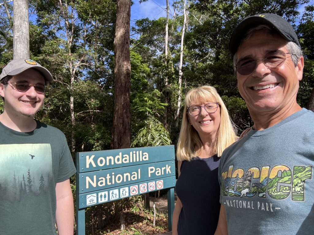 Three people by National park sign