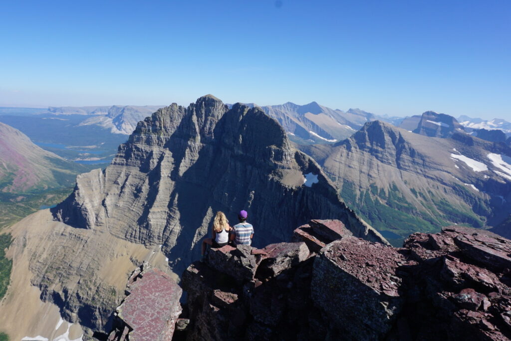 Two people sitting on mountain ledge