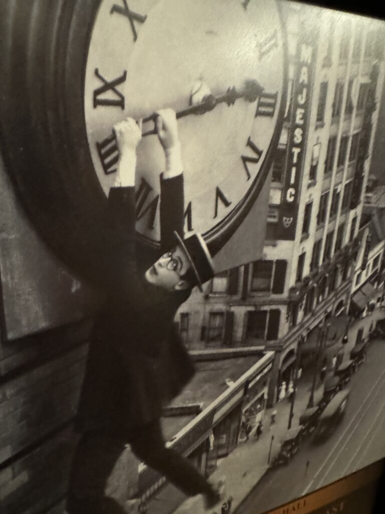 Man hanging from large building clock