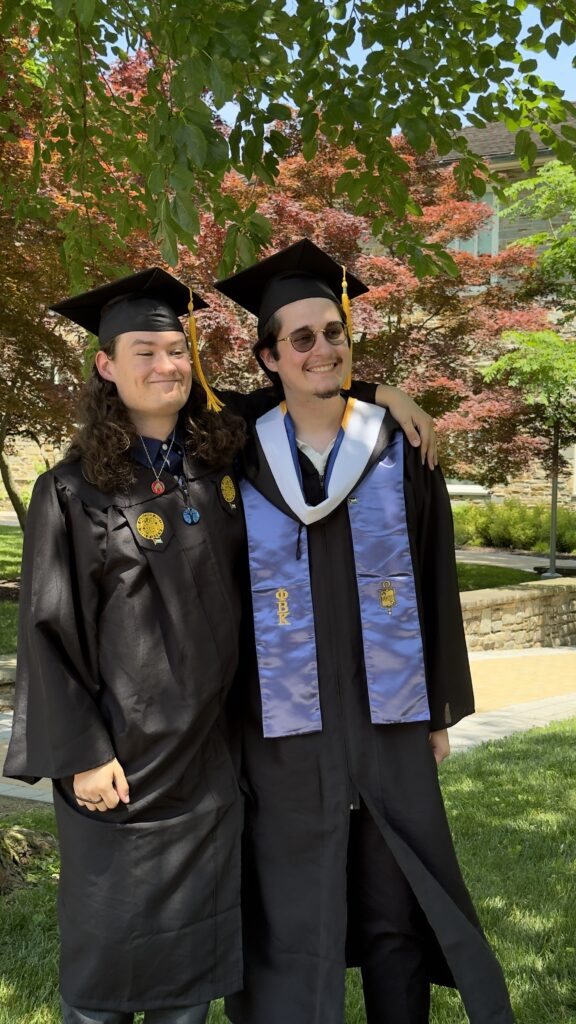 Two college graduates posing for a picture