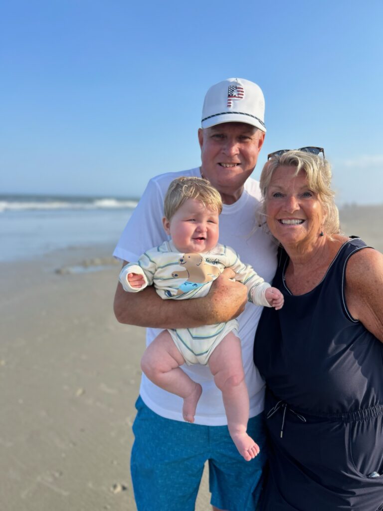 Two grandparents with a grandchild at the beach