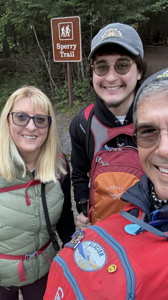 three people at trailhead sign