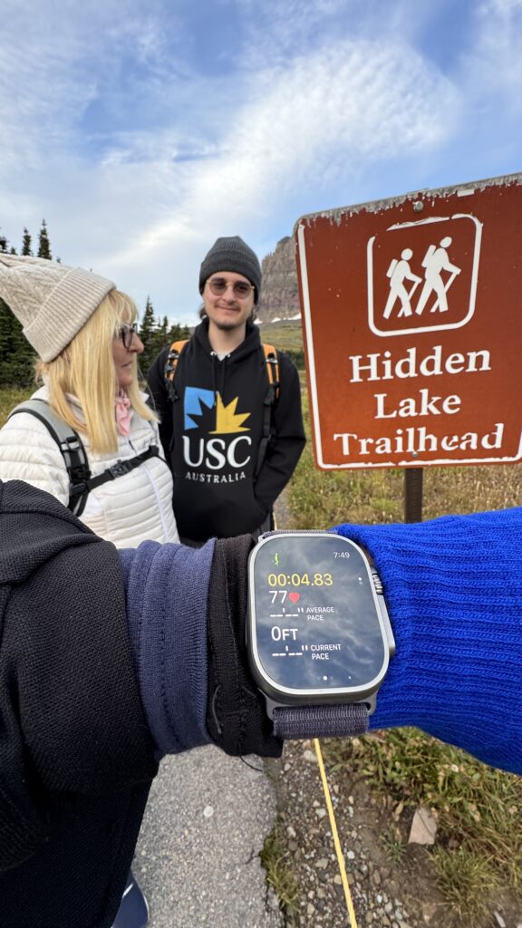 two people at a trailhead sign
