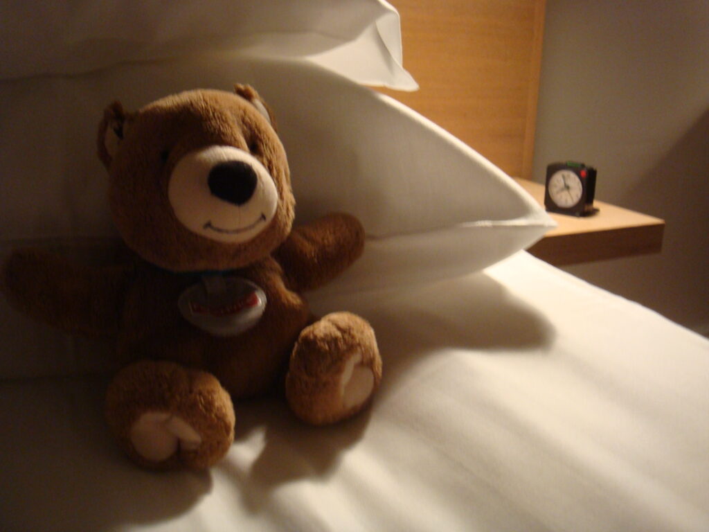 Teddy bear on a hotel room bed